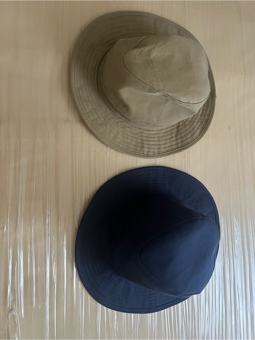 two casual fabric bucket hats featuring a classic tan style paired with a dark n